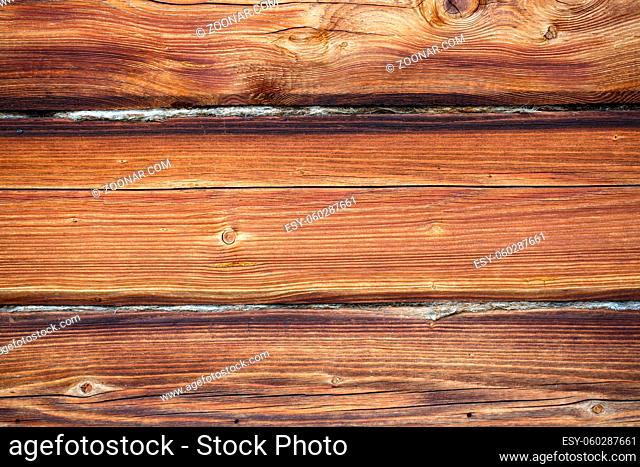 Fragment of an old wooden house with a protruding stick