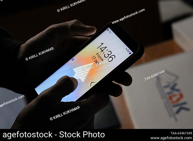 RUSSIA, NOVOSIBIRSK - OCTOBER 17, 2023: A person turns on a new F+ R570e smartphone as Open Mobile Platform lets users beta test the Russian-made Aurora OS at...