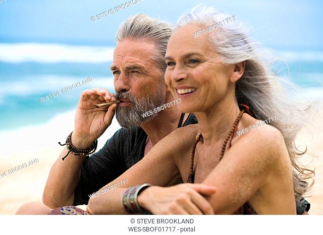 Senior hippie couple relaxing together on the beach