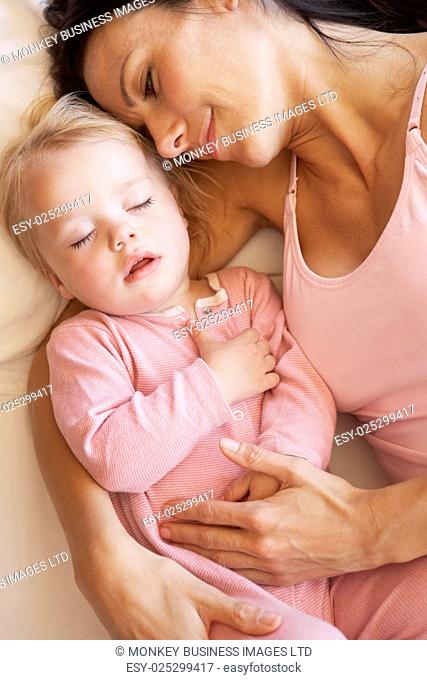 Mother And Daughter Sleeping In Bed