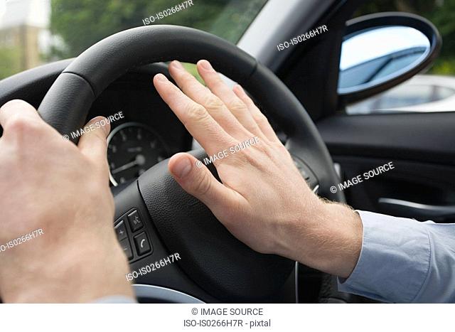 A man pressing a car horn