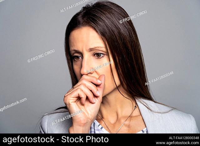 Thoughtful mature woman touching her mouth