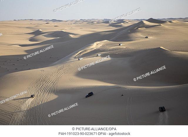 15 October 2019, Egypt, Siwa: A picture made available on 23 October 2019 shows safari cars driving through sand dunes in Egypt's Western Desert