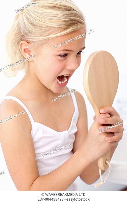 Little girl having fun with a mirror