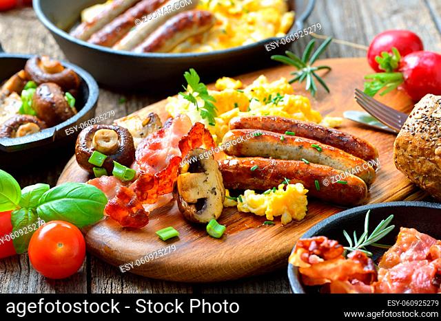 Deftiges, gehaltvolles Bauernfrühstück mit Nürnberger Rostbratwürsten und Rühreiern mit Speck ? A hearty breakfast with scrambled eggs with bacon