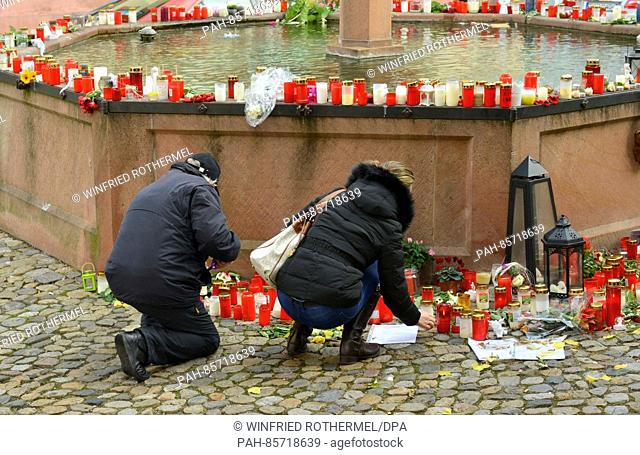 A well in a town square covered in flowers and letters of remembrance in honour of a recently murdered jogger in Endingen, Germany, 17 November 2016