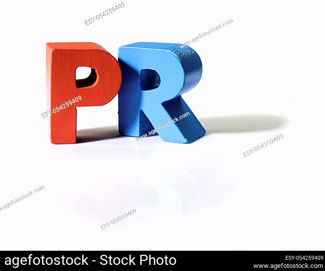 Multicolored text PR made of wood. White background