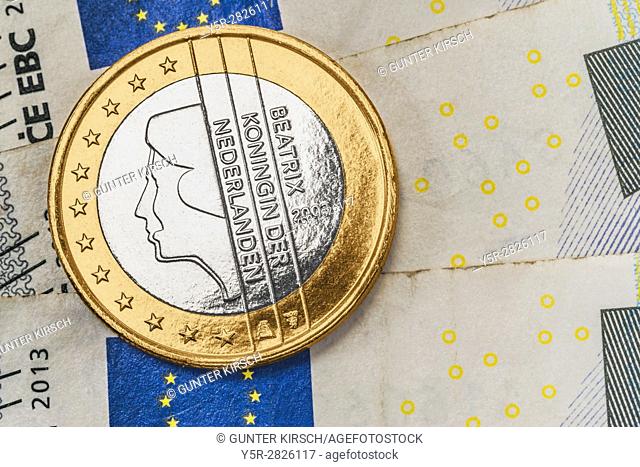 a 1 euro coin from the Netherlands on euro banknotes