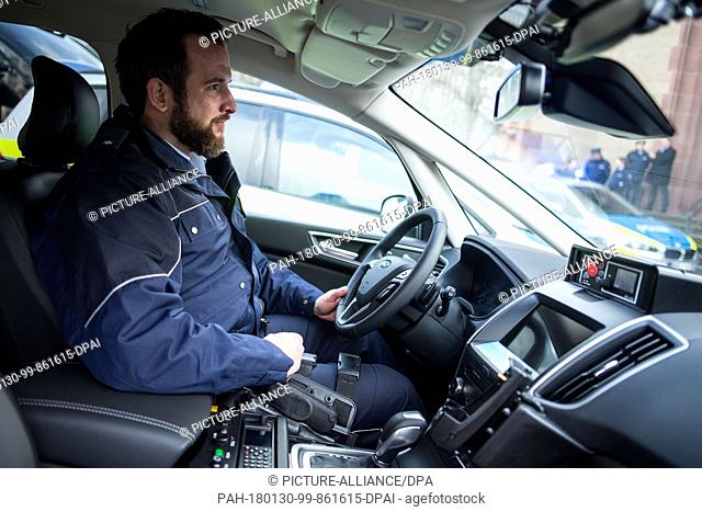 A police officer sitting inside a patrol car of the Ford S-Max type during a press conference by the North Rhine-Westphalia police in Duesseldorf, Germany