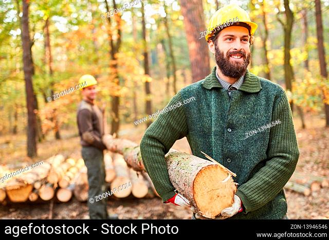 Waldarbeiter oder Holzfäller bei der Holzernte im Wald mit Baumstamm