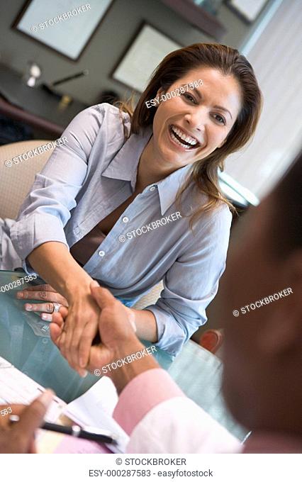 Woman shaking doctor's hand at IVF clinic selective focus