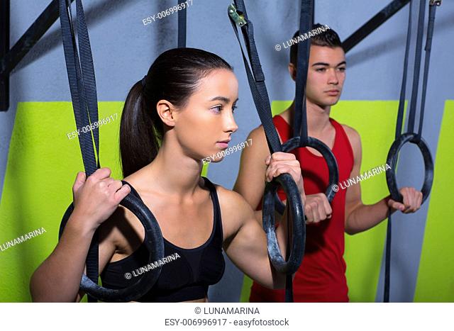 Crossfit dip ring man and woman relaxed after workout at gym dipping exercise
