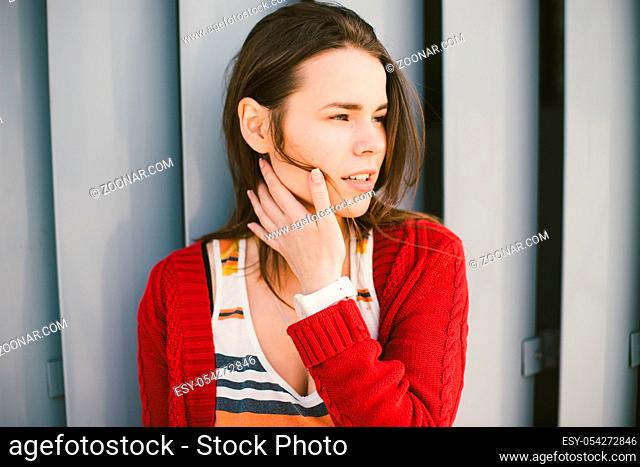 beautiful young girl smiling, is happy, happy , a red shirt over city gray metal wall background