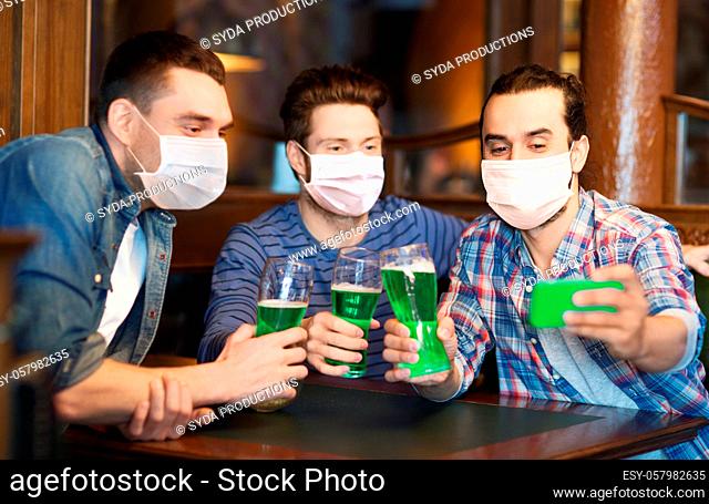 friends with green beer taking selfieat pub