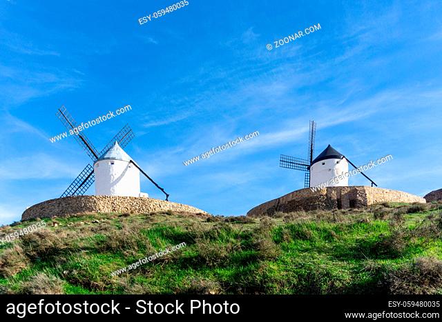 Two traditional whitewashed Spanish windmills in La Mancha on a hilltop above Consuegra