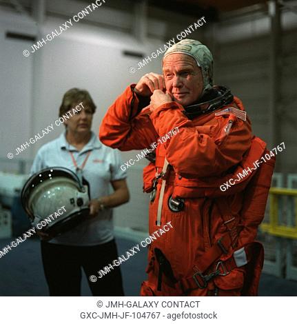 Sen. John H. Glenn Jr. (D.-Ohio), STS-95 payload specialist, checks the communications system on his head gear prior to bailout training at the Johnson Space...