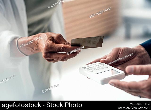Hand of woman paying via credit card