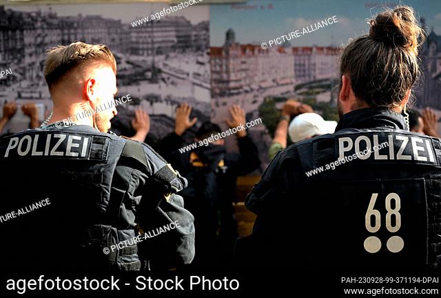 28 September 2023, Hesse, Frankfurt/Main: Police officers stand in front of suspects. The station district is considered a crime hotspot in the banking...