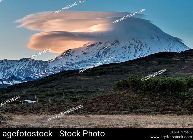 Beautiful clouds over the volcano at sunset. Active Ichinsky Volcano, Kamchatka Peninsula, Far East, Russia, Eurasia