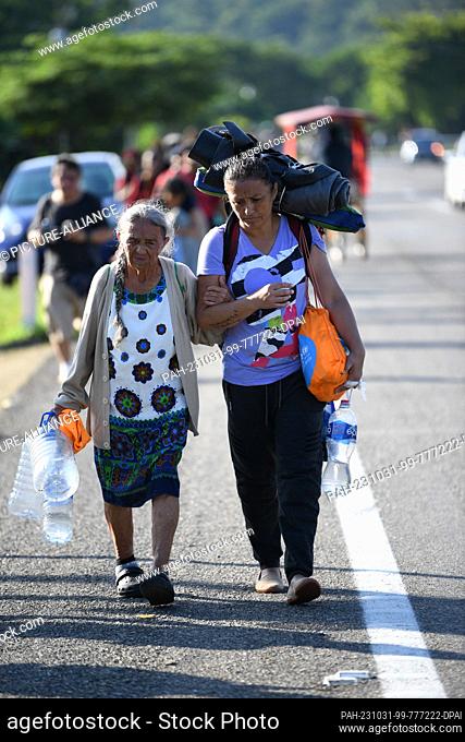 31 October 2023, Mexico, Chiapas: 80-year-old Maria del Carmen Sabogal (l) walks along with ten members of her family in a caravan heading north
