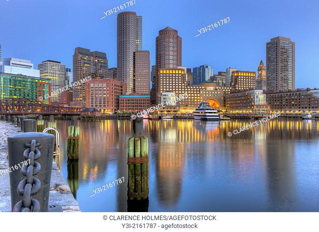 The skyline reflects off the still waters of the harbor in the last hour before sunrise as a new day begins in Boston, Massachusetts, USA