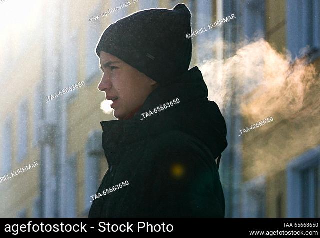 RUSSIA, NOVOSIBIRSK - DECEMBER 12, 2023: A young man exhaling breath vapor is seen in a street in Central District during severe frost in winter