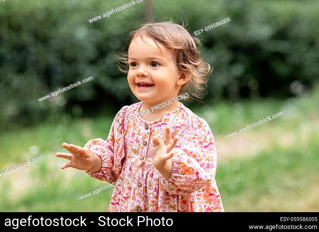 happy little baby girl outdoors in summer