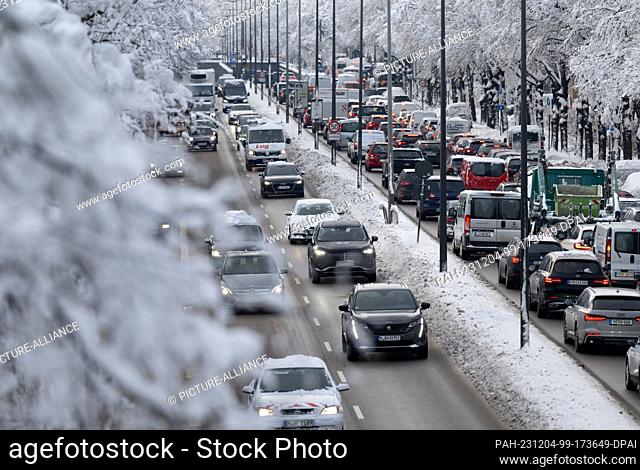 04 December 2023, Bavaria, Munich: Numerous cars drive across the central ring road during rush hour. Snow and ice continue to cause chaos on the roads in the...