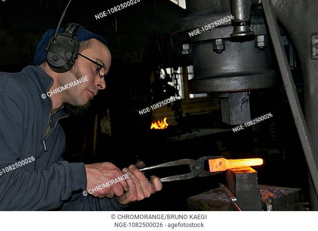 blacksmith working the steamhammer on redhot steel