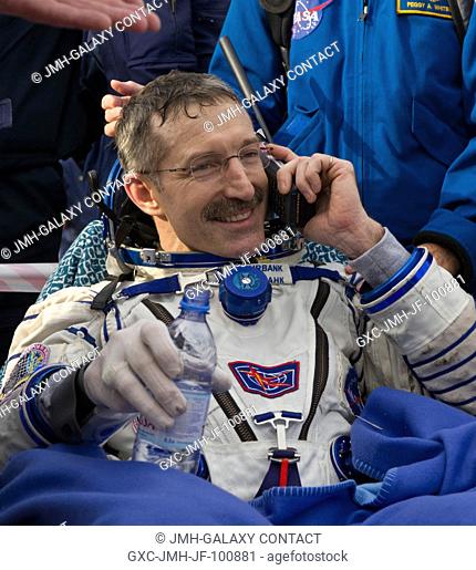 Expedition 30 Commander Dan Burbank speaks with his family via satellite phone outside the Soyuz TMA-22 capsule just minutes after he and Expedition 30 Flight...