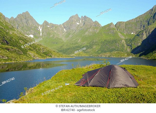 Lonesome tent in the wilderness with lake Agvatnet and mountain Mannen Lofoten Norway