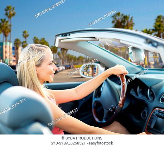 woman driving convertible car over venice beach