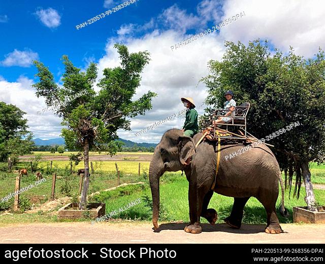 05 May 2022, Vietnam, Dak Lak: Tour riders ride an elephant in Dak Lak province. In the Vietnamese highlands, elephants continue to be exploited for tourist...