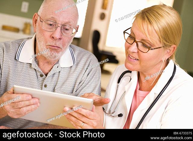 Doctor or nurse talking to senior man with touch pad computer