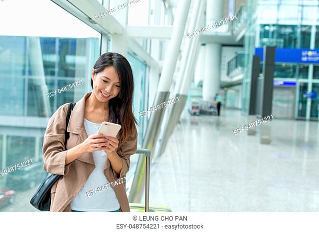 Woman checking on cellphone at Hong Kong airport