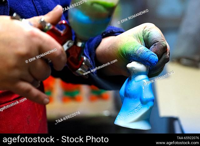 RUSSIA, VORONEZH - DECEMBER 19, 2023: An employee spray paints a Christmas ornament at the Igrushki factory. The enterprise is engaged in production of PVC...