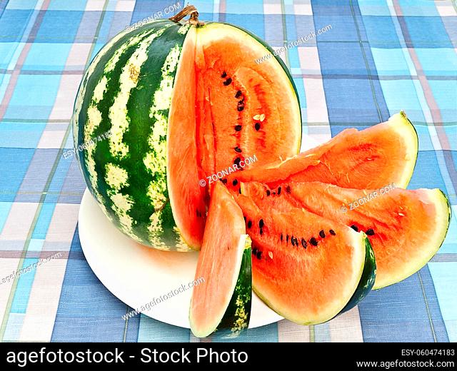 Watermelon With Slices At Plate On Table With Squared Tablecloth