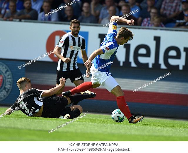 Sandhausen's Lucas Hoeler (l) attacks Kiel's Christopher Lenz during the German 2nd Bundesliga soccer match between Holstein Kiel and SV Sandhausen at the...