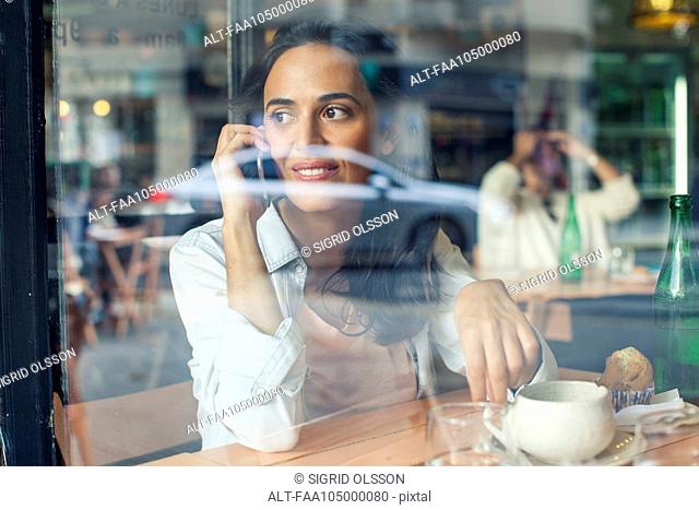 Woman talking on cell phone in coffee shop