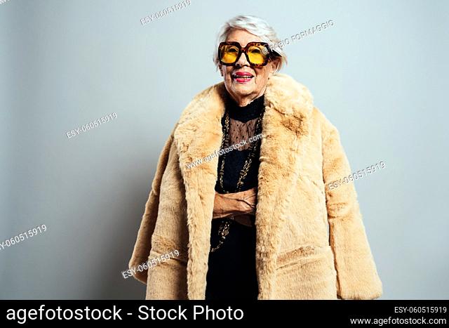 image of a beautiful and elegant old influencer woman. Cool grandmother posing in studio wearing fashionable clothes
