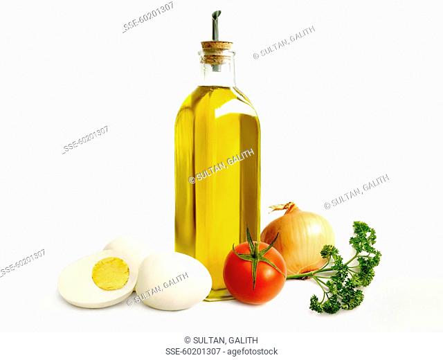 Bottle of olive oil, hard-boiled egg, tomato , onion and parsley