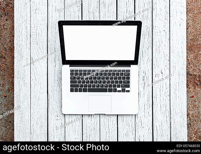 Open laptop with isolated screen on old wooden desk