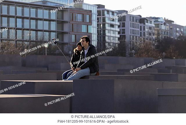 05 December 2018, Berlin: A young couple from Spain makes a selfie in the stele field of the Holocaust Memorial. Photo: Clara Margais/DPA