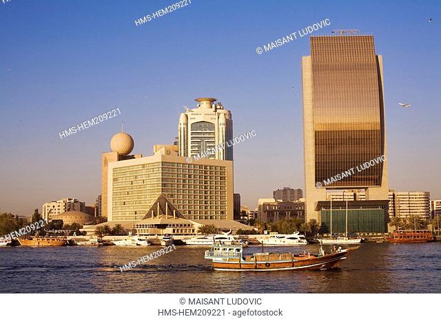 United Arab Emirates, Dubai, Dubai Creek, merchandise ships passing in fron of the Sheraton Dubai Creek, the Dubai Creek Tower and the National Bank of Dubai by...