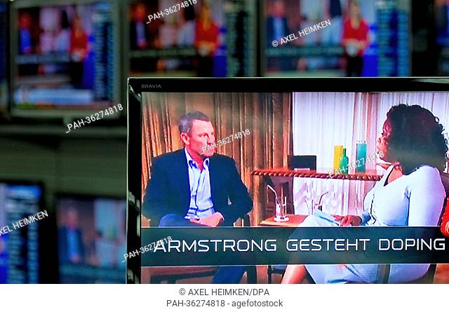 TV screens display US talkmaster Oprah Winfrey talking to former US cyclist Lance Armstrong in an early recorded interview