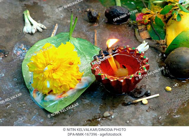 Ignited earthen oil lamp with flower and fruit on vat savitri festival
