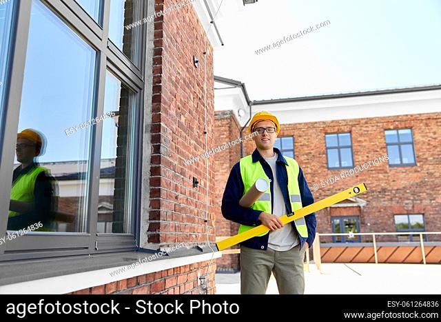 male architect in helmet with level on site
