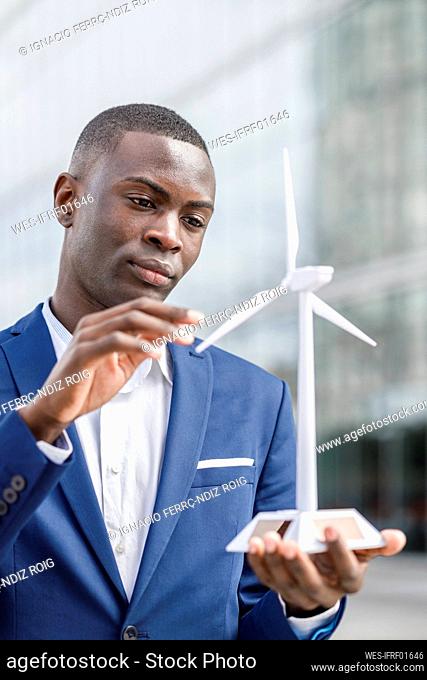 Young engineer examining wind turbine model