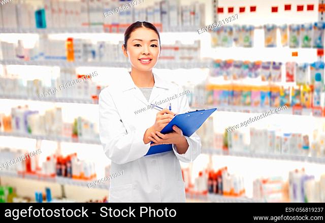 happy asian female pharmacist with clipboard
