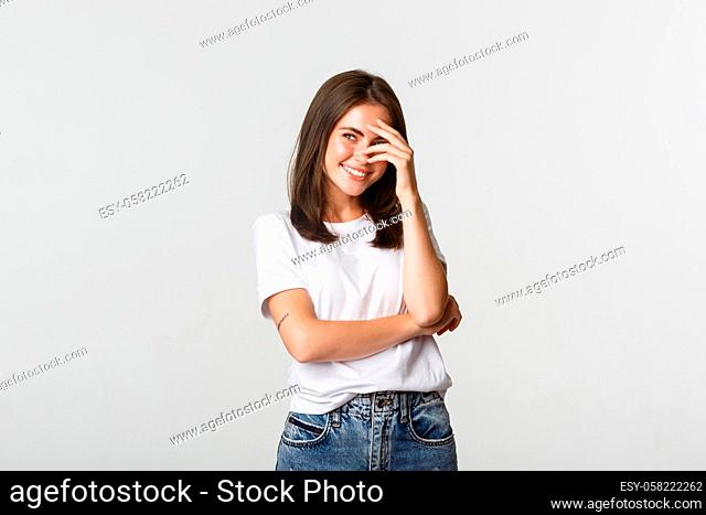 Flirty beautiful girl cover face with hand while laughing and looking upper left corner